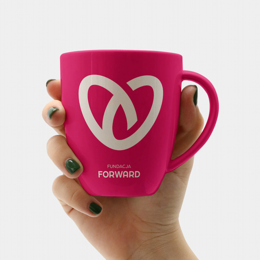 Hand holding a cup with the Forward Foundation logo on a grey background